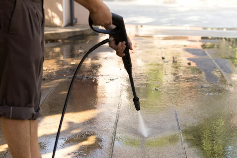 Pressure washer cleaning a concrete driveway
